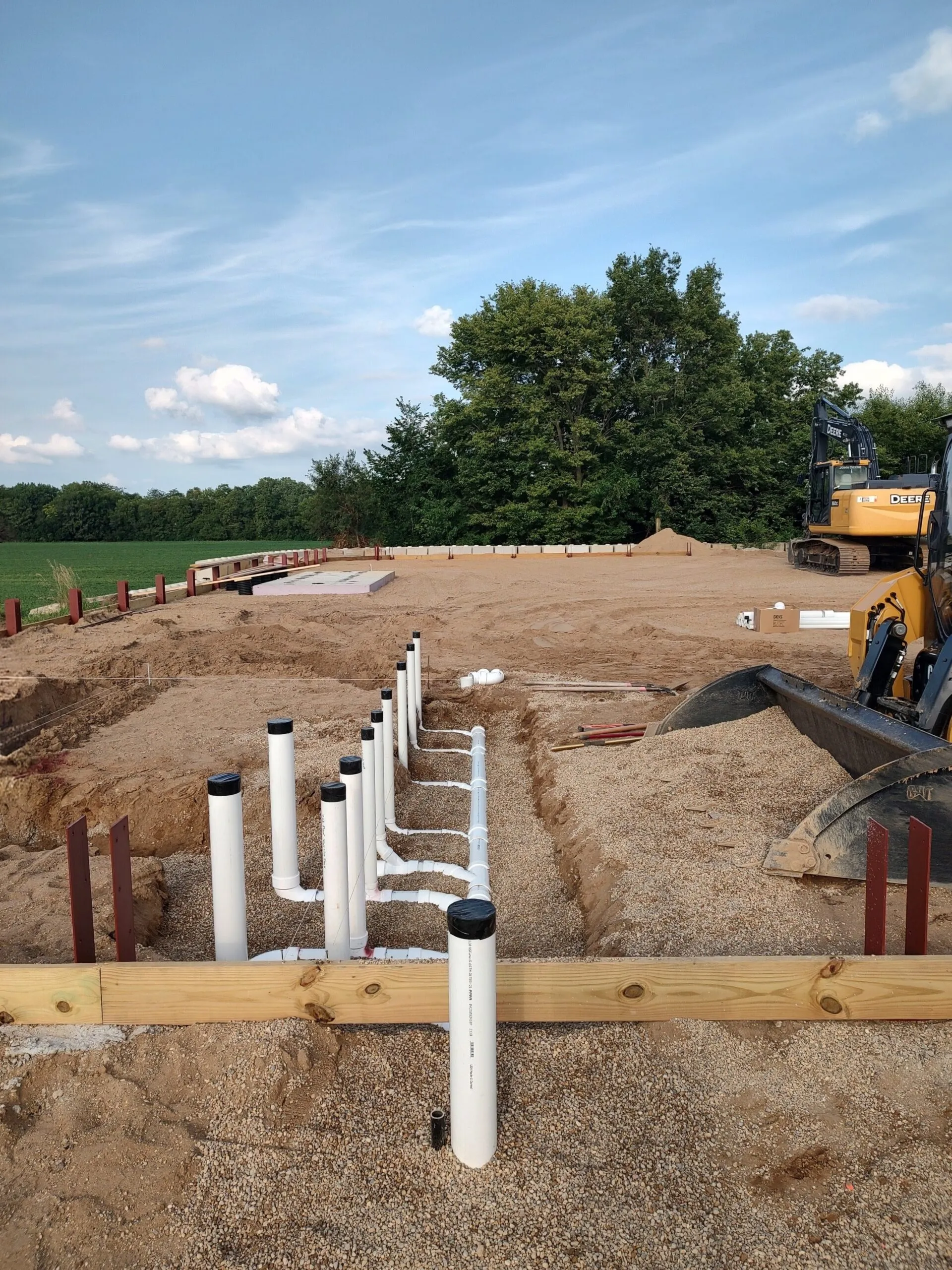 Underground sewer and water rough-in staked out on a new commercial building pad