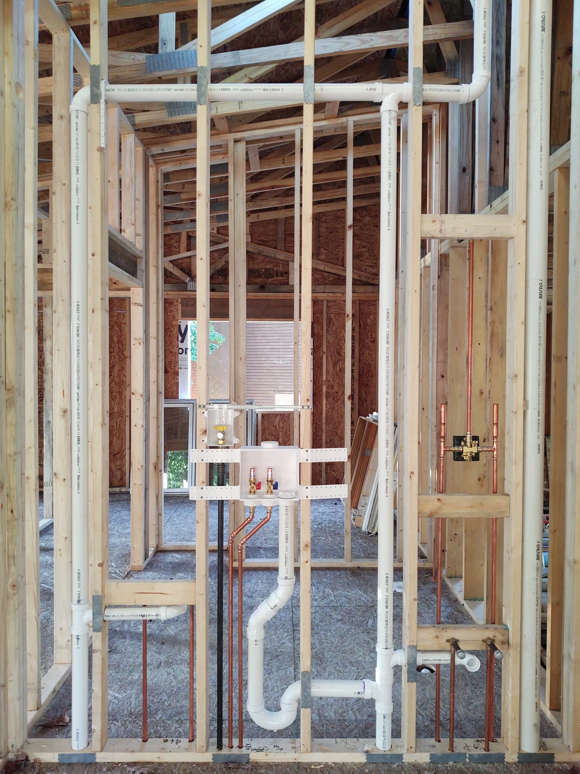 Copper and PVC rough-in inside a framed interior wall