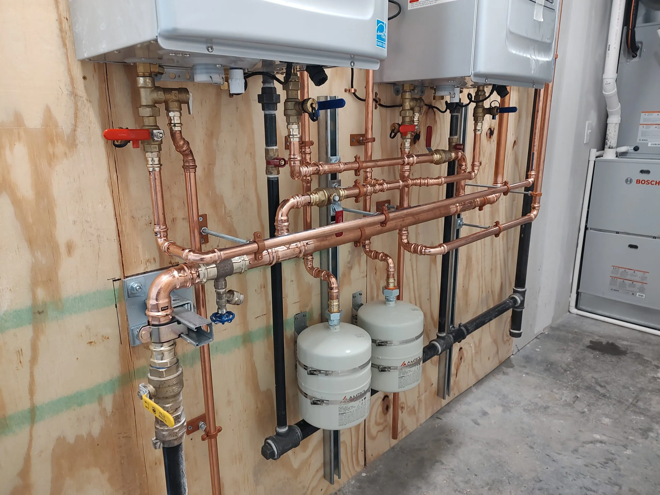 Tankless water heater with a copper manifold, shutoffs and expansion tanks